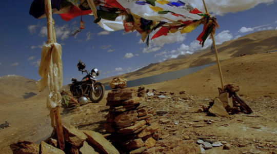 Royal Enfield et drapeau à prière au lac Tsomoriri - Voyage à moto Transhimalayenne et Ladakh, Inde, Himalaya