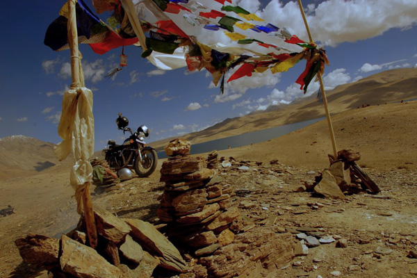 Royal Enfield et drapeau à prière au lac Tsomoriri - Voyage à moto Transhimalayenne et Ladakh, Inde, Himalaya